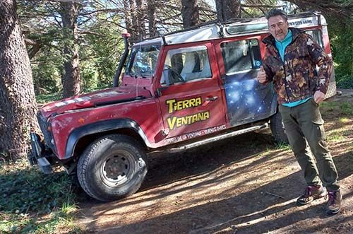 Guía junto al Land Rover en la sierra, día soleado